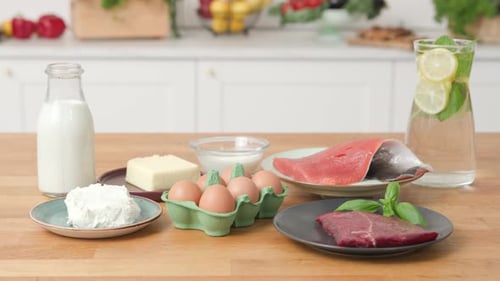 Mesa de cocina de madera llena de productos alimenticios de origen animal: carne, pescado, huevos, lácteos. Shot y estático
