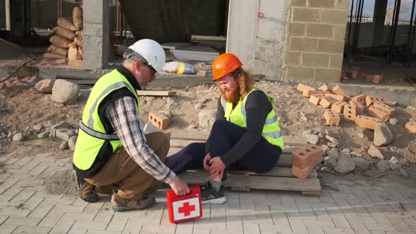 Male engineer suffered a injury at work calls a colleague with a first ...