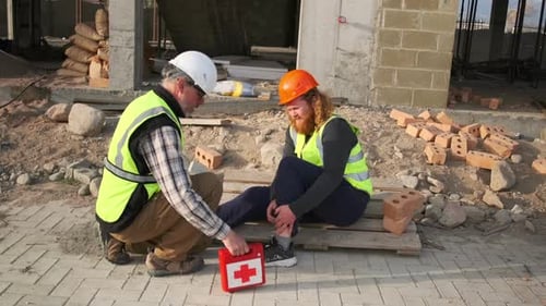 Engenheiro do sexo masculino sofreu uma lesão no trabalho liga para um colega com um kit de primeiros socorros para ajudar, danificar o corpo