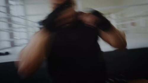 Strong Black Boxer Throws Punches During Intense Training in Gym