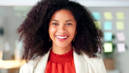 Portrait of a black business woman smiling and laughing while working in an office
