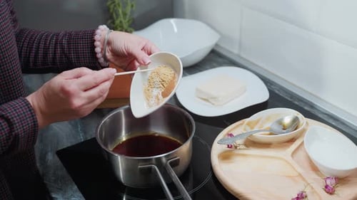 Woman Adds Spices to Cooking Pot