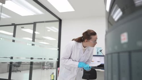 Female Scientist Inspects Equipment and Documents Results