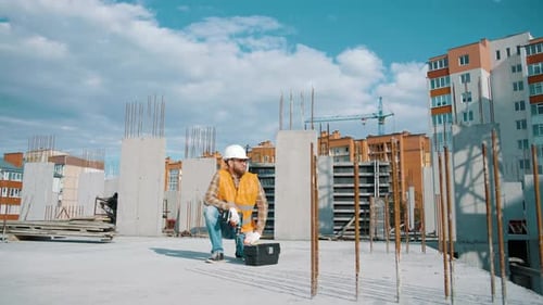 Construction Worker Opening Toolbox at Building Site