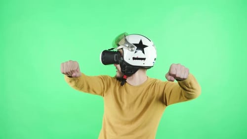 Man in helmet and VR headset pretends driving