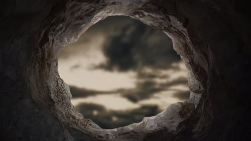 Dark Cave Opening Revealing Cloudy Sky View