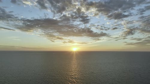 Sun Setting Down In The Ocean With A Beautiful Orange Sky With A Clear Horizon A Top Drone Shot
