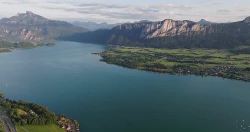 Lake Views Amidst Lush Fields, Town, And Majestic Peaks