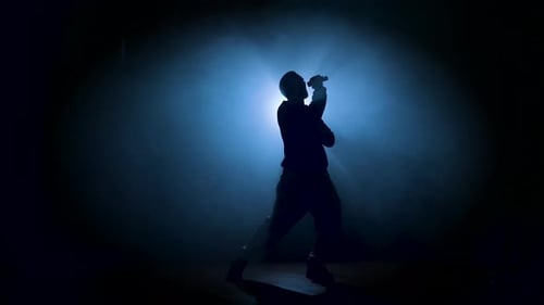 Silhouetted Singer Performing with Microphone in Smoky Light