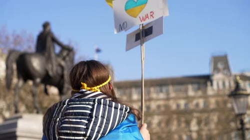 London stands with Ukraine, child protesting waving sign of peace, protester in Trafalgar Square in
