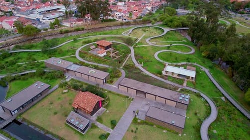 um dia no parque que fica ao lado do rio ao meio-dia visto de um drone com a grama verde com sete