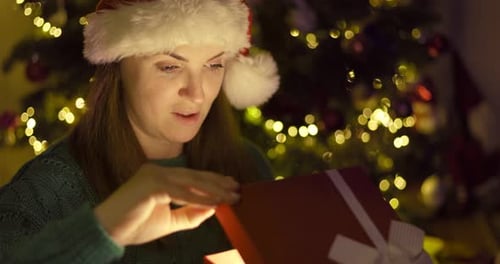 Woman Opening Gift Box at Christmas Time
