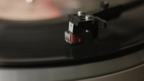 An extreme close-up of a stylus playing, on a vintage turntable, a record player.