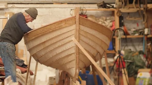 Boat builder working on clinker lapstrake dinghy boat