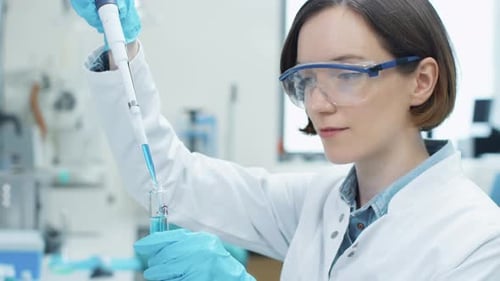 Portrait of Young Woman Scientist Working in Laboratory, using Micropipette.