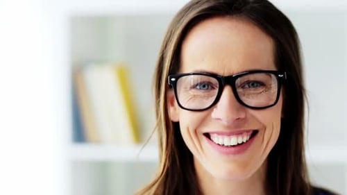 Smiling woman portrait wearing eyeglasses indoors, close-up