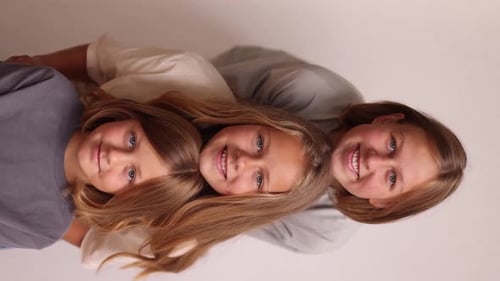 Faces of Three Girls in a Row in Casual Clothes