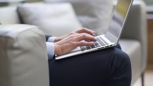 Nahaufnahme eines Geschäftsmannes, der auf der Laptoptastatur tippt