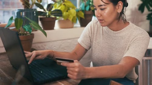Woman Using Laptop and Holding Credit Card
