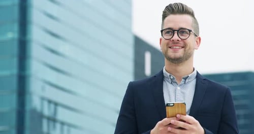 A young businessman using a cellphone in the city