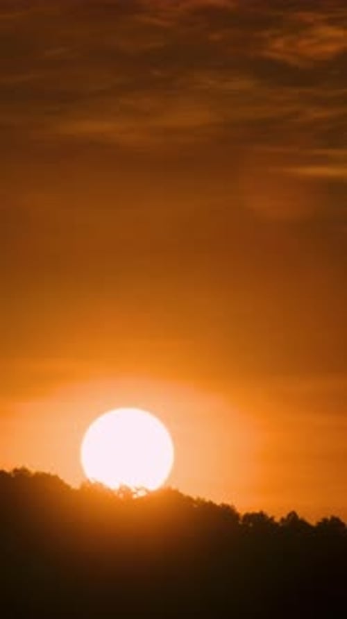 Timelapse of dramatic sunrise with orange sky in a sunny day.