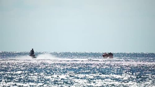Jet Ski Pulls Banana Boat in Sparkling Ocean