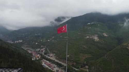 Aerial View of Turkish Flag Waving Over Mountain Scenery