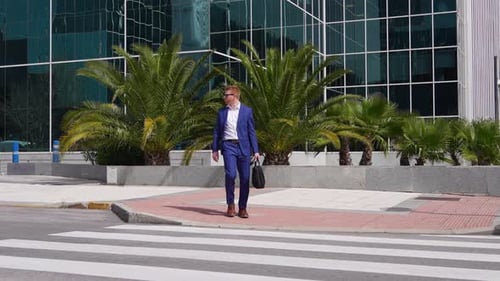 Businessman Crossing the Street in Front of Modern Office Building