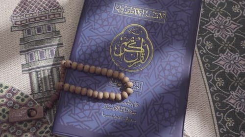 The Quran lies atop a prayer mat