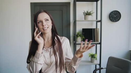 Business Lady in a Business Suit Talking on the Phone in the Office