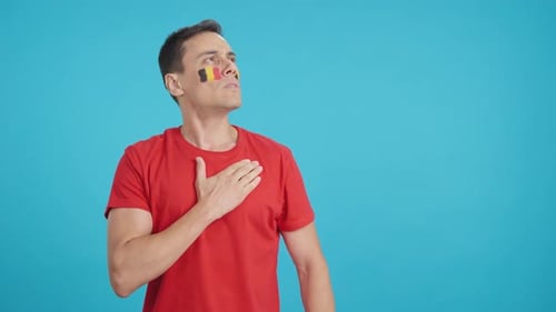 Man Listening to the Belgium National Anthem with Solemnity