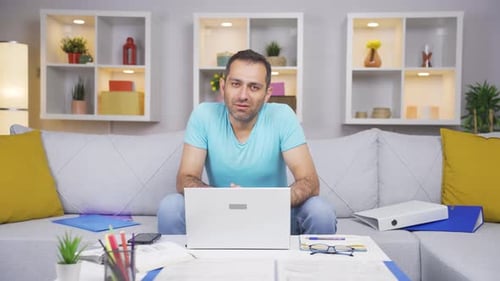 Home office worker man looking emotional at camera.