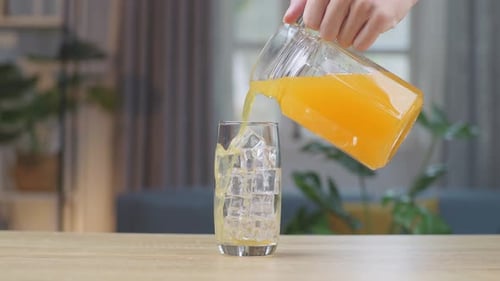Juice Being Poured Over Ice in Glass