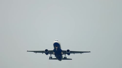 Airplane Ascending into Overcast Sky on Cloudy Day