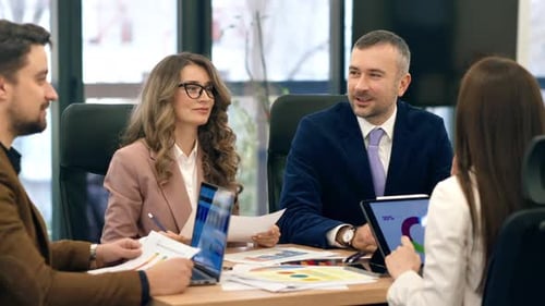 Business meeting in an office, workers discussing business affairs. Gadgets and papers with charts o