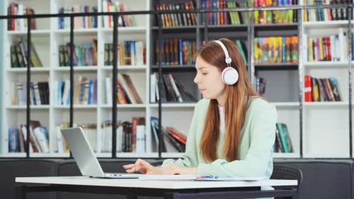 Young Adult Student Working on Laptop in Library