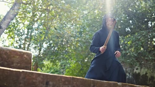 Hooded Figure with Sword Posing on Steps
