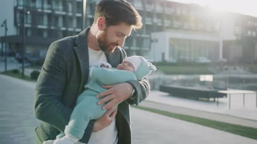 Beautiful Shot Attractive Happy Young Father Holds a Small Cute New Born Daughter at Sunlight Stand