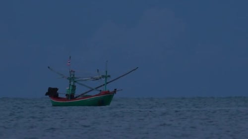 Fishing Boats in Thailand wait in the middle of the ocean for dark to come so they can turn on their