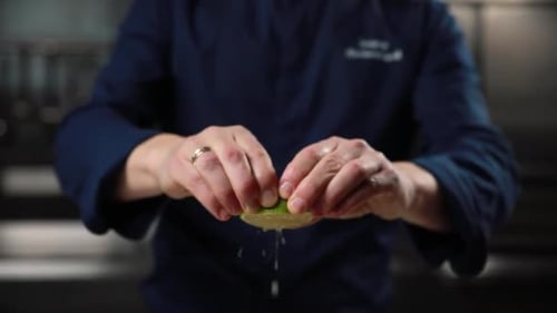 the chef squeezes a lime in the kitchen