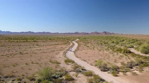Aerial, drone shot following a delivery truck, on a desert road, sunny day, in Arizona, USA