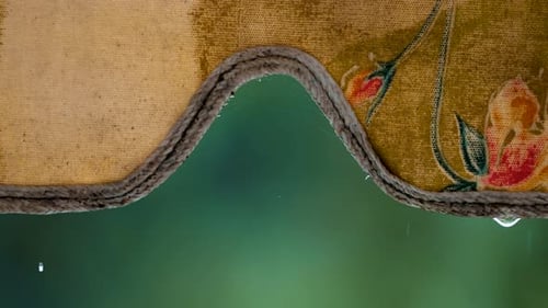 Pedestal downward shot of rain dripping off of garden furniture. Deep depth of field shot on a long