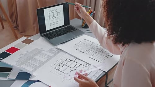Black Woman Compares House Apartment Layout on Laptop