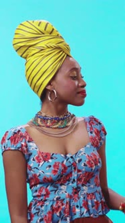 A Fashionable Woman Dressed in a Stunning Floral Dress Complemented By a Bright Yellow Headwrap