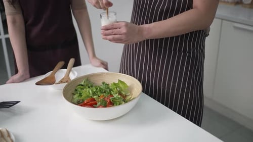 People Making a Salad Together in Kitchen