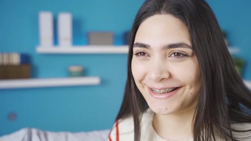 Smiling Young Woman Relaxing on Couch at Home