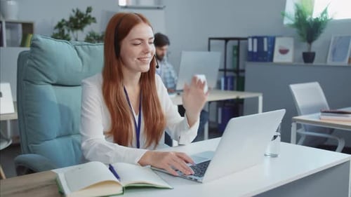 A Focused Woman Works at Her Desk on a Laptop Showing Productivity
