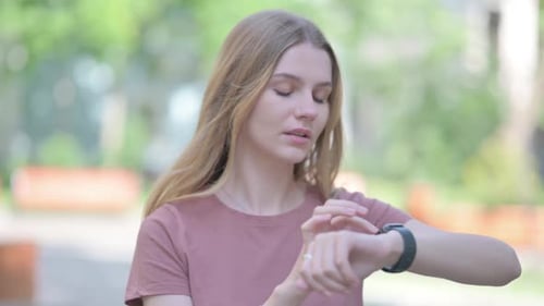 Young Woman Using Smartwatch in Urban Setting