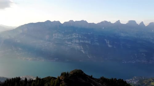 Aerial view of lake Walensee, surrounded by cliffs and the mountain peaks such as the Churfirsten as