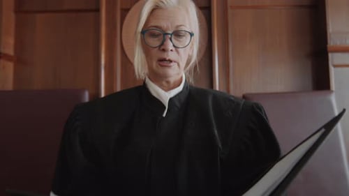 Senior Judge Holding Folder and Reading out Verdict after Court Trial